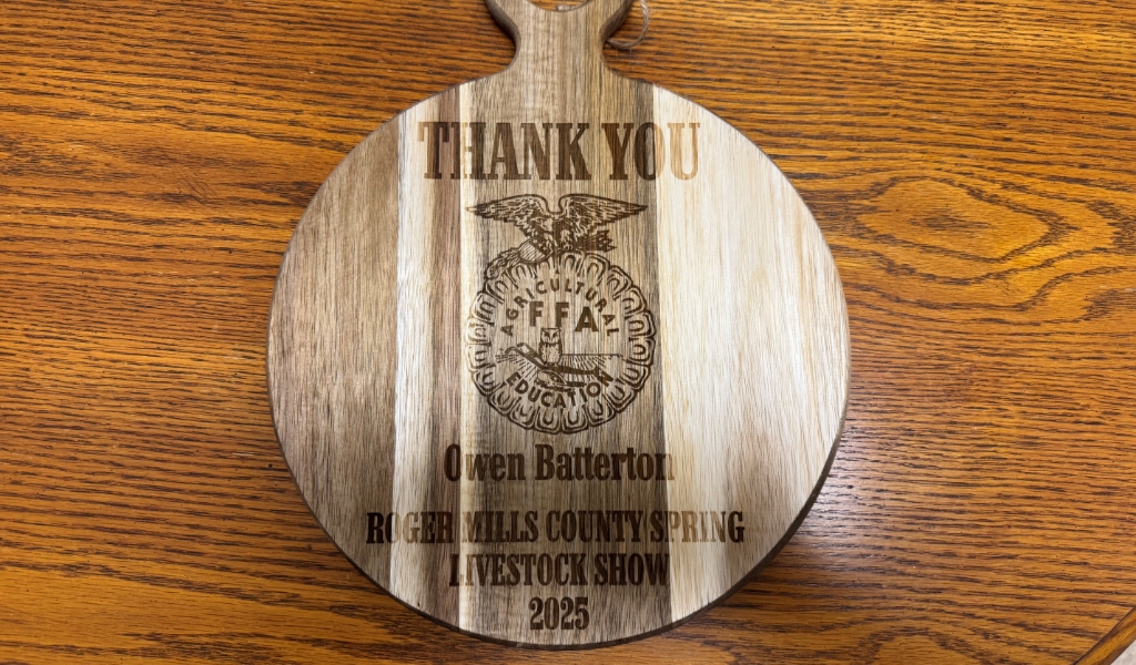 Wooden plaque featuring the FFA logo and the text: "Thank You, Owen Batterton, Roger Mills County Spring Livestock Show, 2025," set against a wooden background.